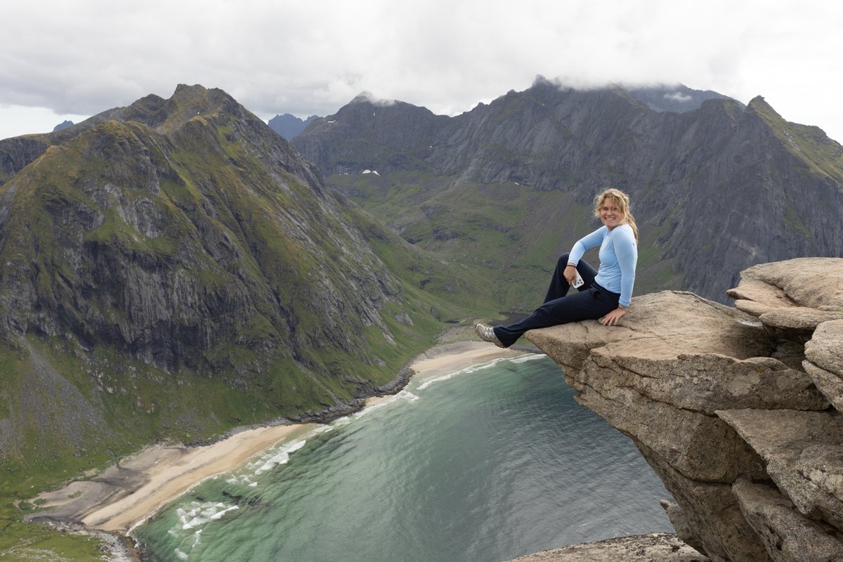 Woman sitting on a cliff edge above the sea